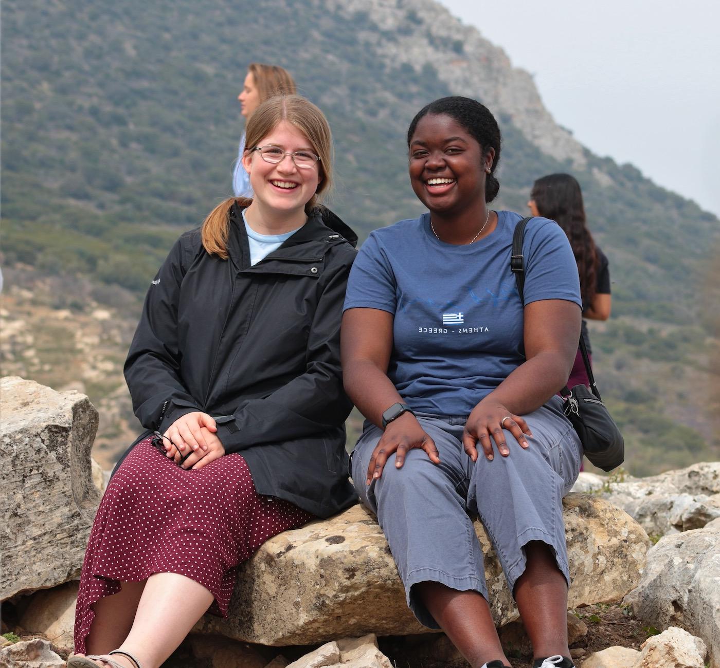 Two female students on hillside in the Mediterranean